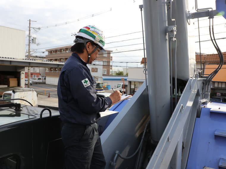 クレーンの点検記録をつける作業員